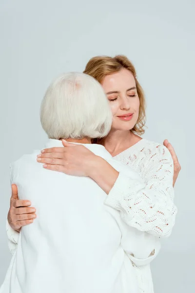 Rückansicht der Mutter umarmt lächelnde Tochter isoliert auf grau — Stockfoto