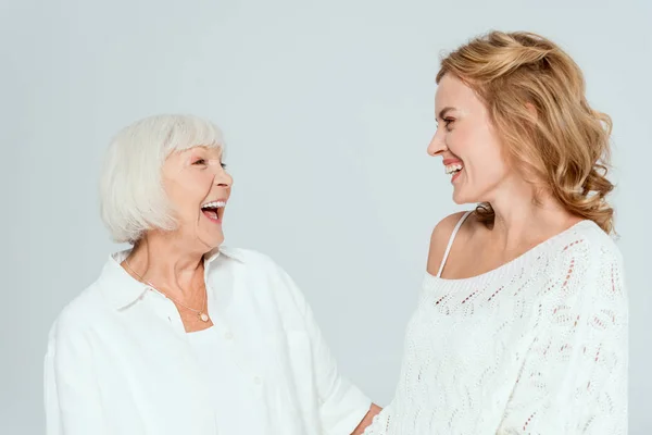 Attractive mother and smiling daughter looking at each other isolated on grey — Stock Photo