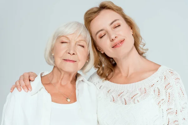 Lächeln Tochter umarmt attraktive Mutter mit geschlossenen Augen isoliert auf grau — Stockfoto