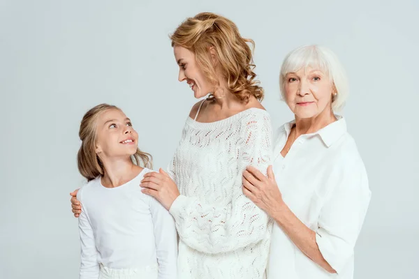 Sorridente nipote, madre e nonna che si abbracciano isolate sul grigio — Foto stock