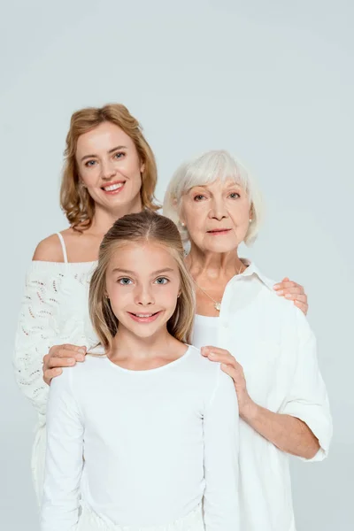 Smiling mother, grandmother and granddaughter hugging isolated on grey — Stock Photo