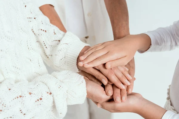 Vue recadrée de la mère, grand-mère et petite-fille tenant les mains isolées sur gris — Photo de stock