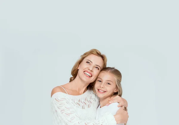 Attractive mother hugging smiling daughter and looking up isolated on grey — Stock Photo