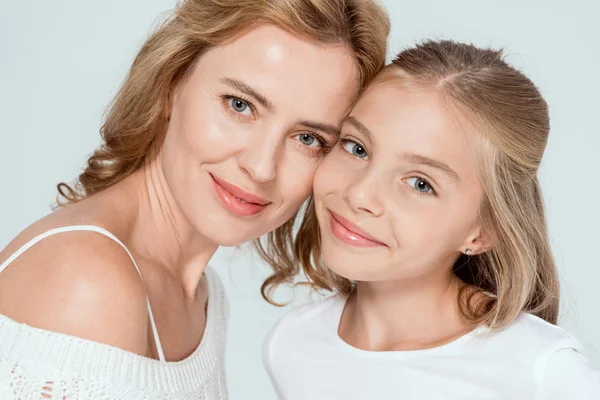 Atractiva madre e hija sonriente mirando a la cámara aislada en gris - foto de stock