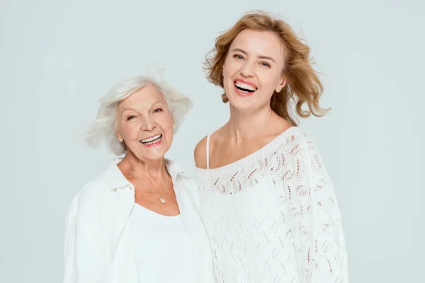 Smiling mother and daughter looking at camera isolated on grey — Stock Photo