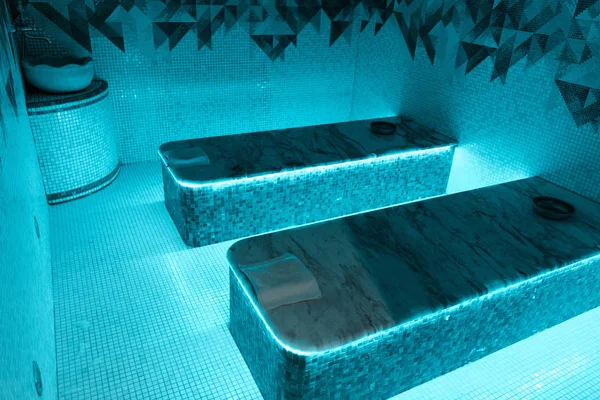 Vue grand angle des tables de hammam avec lumières bleues dans le salon de spa — Photo de stock