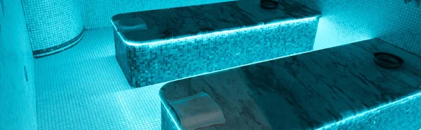 Vue panoramique des tables de hammam avec des lumières bleues dans le salon de spa — Photo de stock