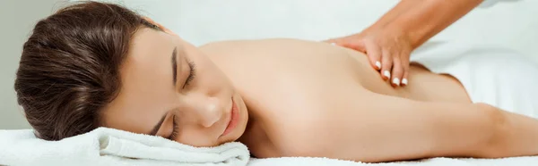 Plano panorámico de masajista haciendo masaje de espalda a mujer atractiva en spa - foto de stock