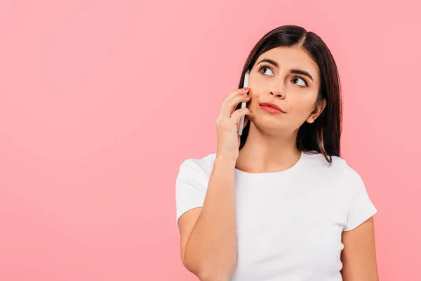 Dreamy pretty brunette girl talking on smartphone isolated on pink — Stock Photo