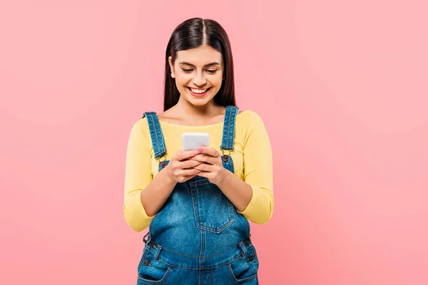 Sorridente incinta bella ragazza utilizzando smartphone isolato su rosa — Foto stock