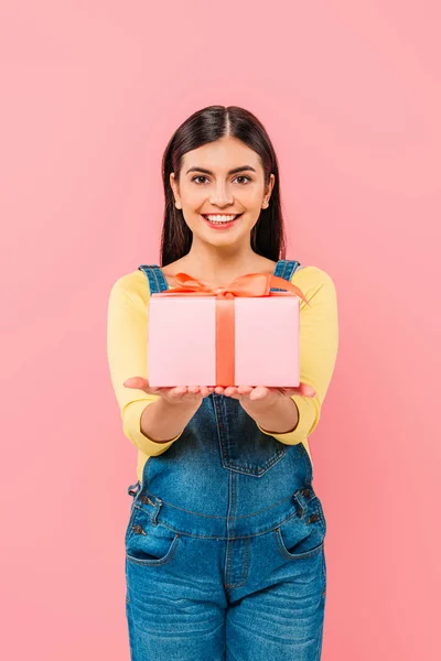 Happy pregnant pretty girl holding gift box isolated on pink — Stock Photo