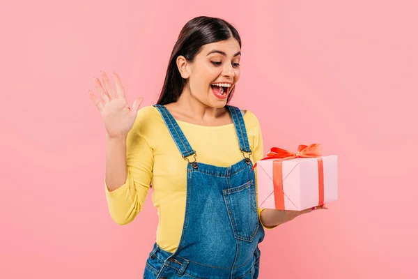 Aufgeregt schwangeres hübsches Mädchen hält Geschenkbox isoliert auf rosa — Stockfoto