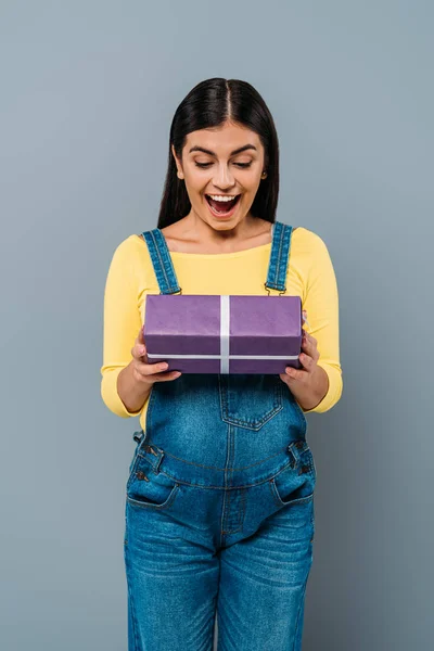 Excited pregnant pretty girl holding present isolated on grey — Stock Photo