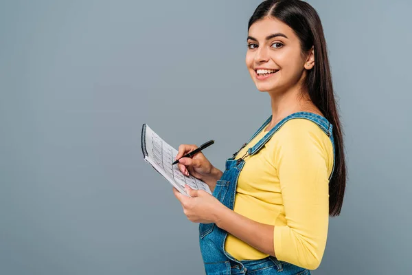 Side view of smiling pregnant pretty girl holding period calendar and pen isolated on grey — Stock Photo