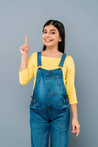 Smiling pregnant pretty girl showing idea gesture isolated on grey — Stock Photo