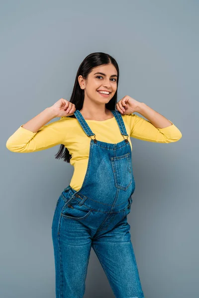 Smiling pregnant pretty girl in dungarees isolated on grey — Stock Photo