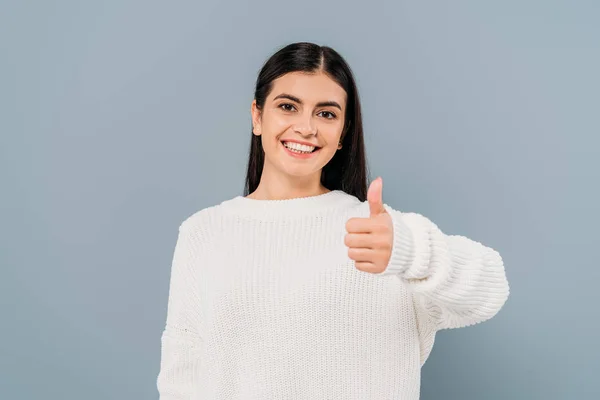 Happy pretty brunette girl in white sweater showing thumb up isolated on grey — Stock Photo