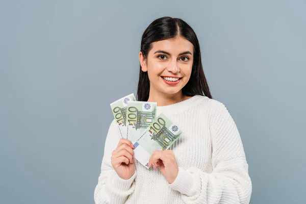 Menina bonita sorridente em camisola branca segurando notas de euro isolado em cinza — Fotografia de Stock