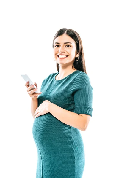 Усміхнена вагітна дівчина використовує смартфон ізольовано на білому — стокове фото