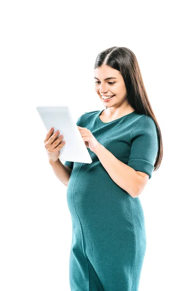Усміхнена вагітна дівчина використовує цифровий планшет ізольовано на білому — стокове фото