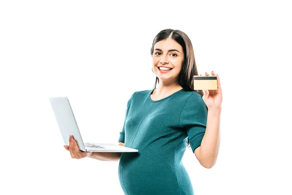 Усміхнена вагітна дівчина тримає ноутбук і кредитну картку ізольовано на білому — стокове фото