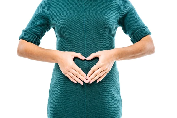 Vista recortada de la chica embarazada que muestra el gesto del corazón en el vientre aislado en blanco - foto de stock