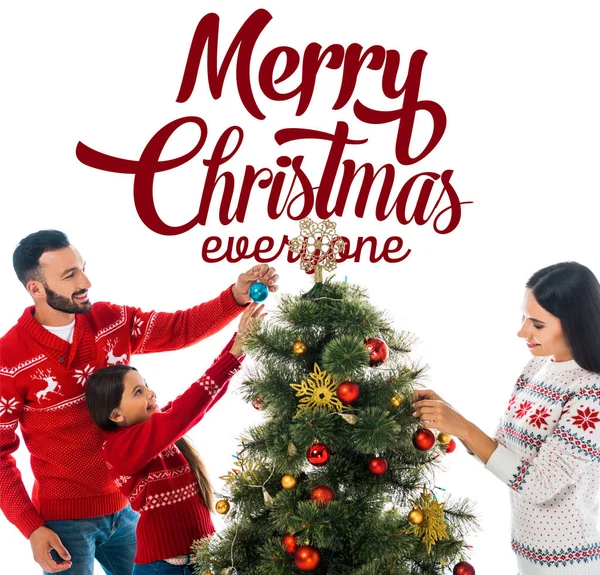 Счастливая дочь украшая елку рядом с родителями изолированы на белом с веселым Рождеством все буквы — стоковое фото