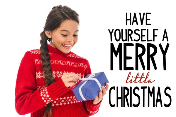 Happy kid in sweater looking at present isolated on white with have yourself a merry little Christmas illustration — Stock Photo