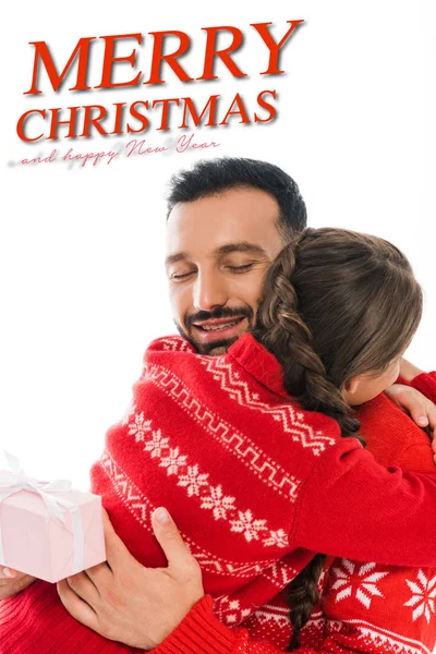 Vue arrière de fille embrassant père heureux avec cadeau de Noël isolé sur blanc avec joyeux Noël et heureux nouveau lettrage de l'année — Photo de stock