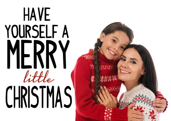 Happy kid hugging cheerful mother in sweater isolated on white with have yourself a merry little Christmas illustration — Stock Photo