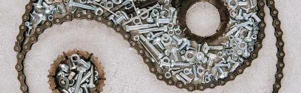 Top view of aged metal gears and screws arranged in taijitu symbol on grey background, panoramic shot — Stock Photo