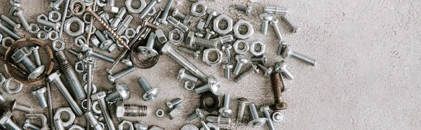 Draufsicht auf Metallschrauben und Nägel auf grauem Hintergrund verstreut, Panoramaaufnahme — Stockfoto