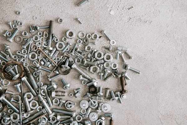 Draufsicht auf Metallschrauben und Nägel auf grauem Hintergrund — Stockfoto