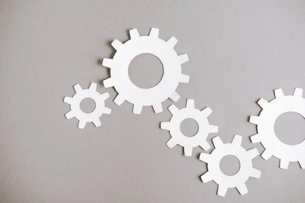 Top view of white gears on grey background — Stock Photo