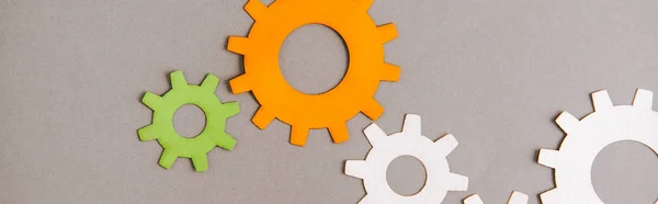 Top view of colorful gears on grey background, panoramic shot — Stock Photo