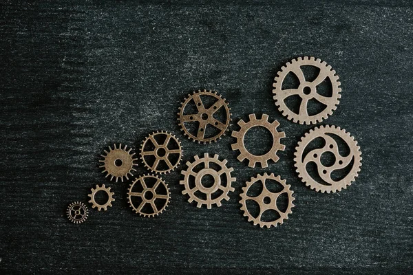 Top view of retro metal gears on dark wooden background — Stock Photo