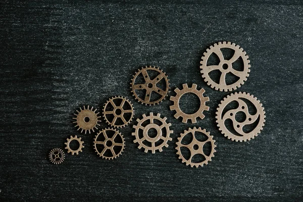 Vista superior de engranajes de metal retro sobre fondo de madera oscura - foto de stock