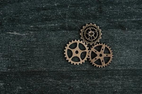 Top view of vintage metal gears on dark wooden background with copy space — Stock Photo