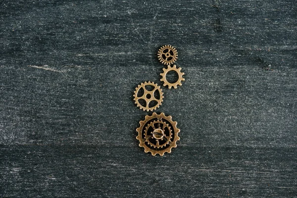 Top view of vintage metal gears on dark wooden background with copy space — Stock Photo