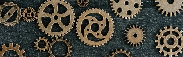 Top view of vintage metal gears on dark wooden background, panoramic shot — Stock Photo