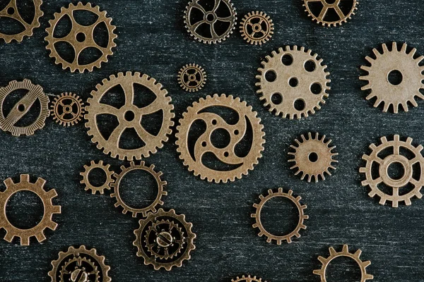 Top view of vintage metal gears on dark wooden background — Stock Photo