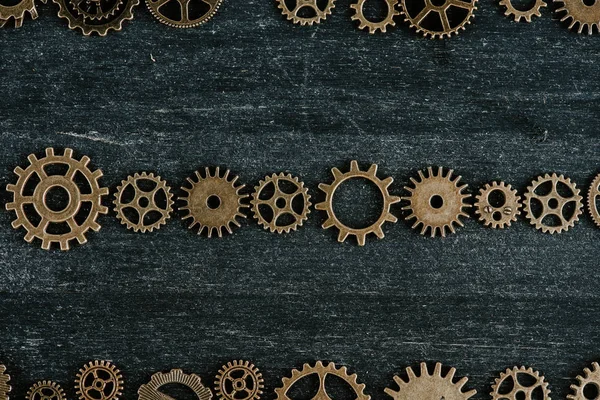 Flat lay with vintage metal gears on dark wooden background — Stock Photo