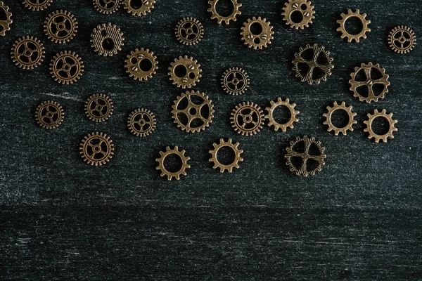 Top view of vintage metal gears on dark wooden background — Stock Photo