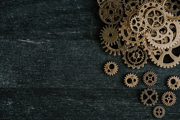 Top view of vintage metal gears on dark wooden background — Stock Photo