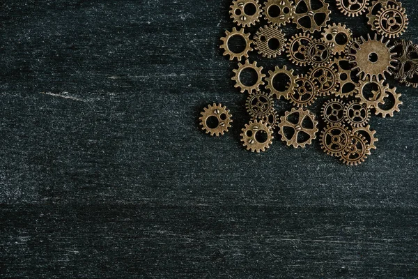 Top view of vintage metal gears on dark wooden background — Stock Photo