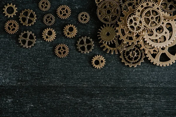 Top view of aged metal gears on dark wooden background — Stock Photo