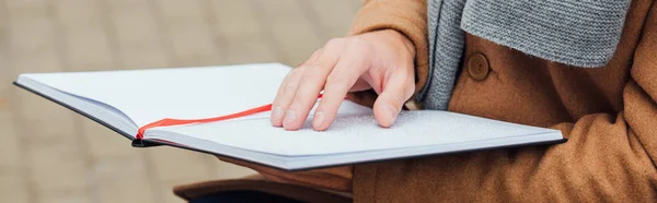 Vista recortada del ciego leyendo libro con fuente braille, plano panorámico - foto de stock