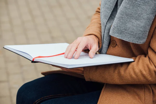 Ausgeschnittene Ansicht eines blinden Mannes, der im Freien ein Buch mit Brailleschrift liest — Stockfoto