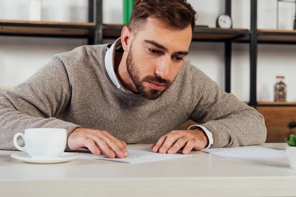 Blind man reading braille font beside coffee at table — Stock Photo