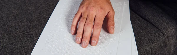 Vista recortada del ciego leyendo la fuente braille en el sofá, plano panorámico - foto de stock